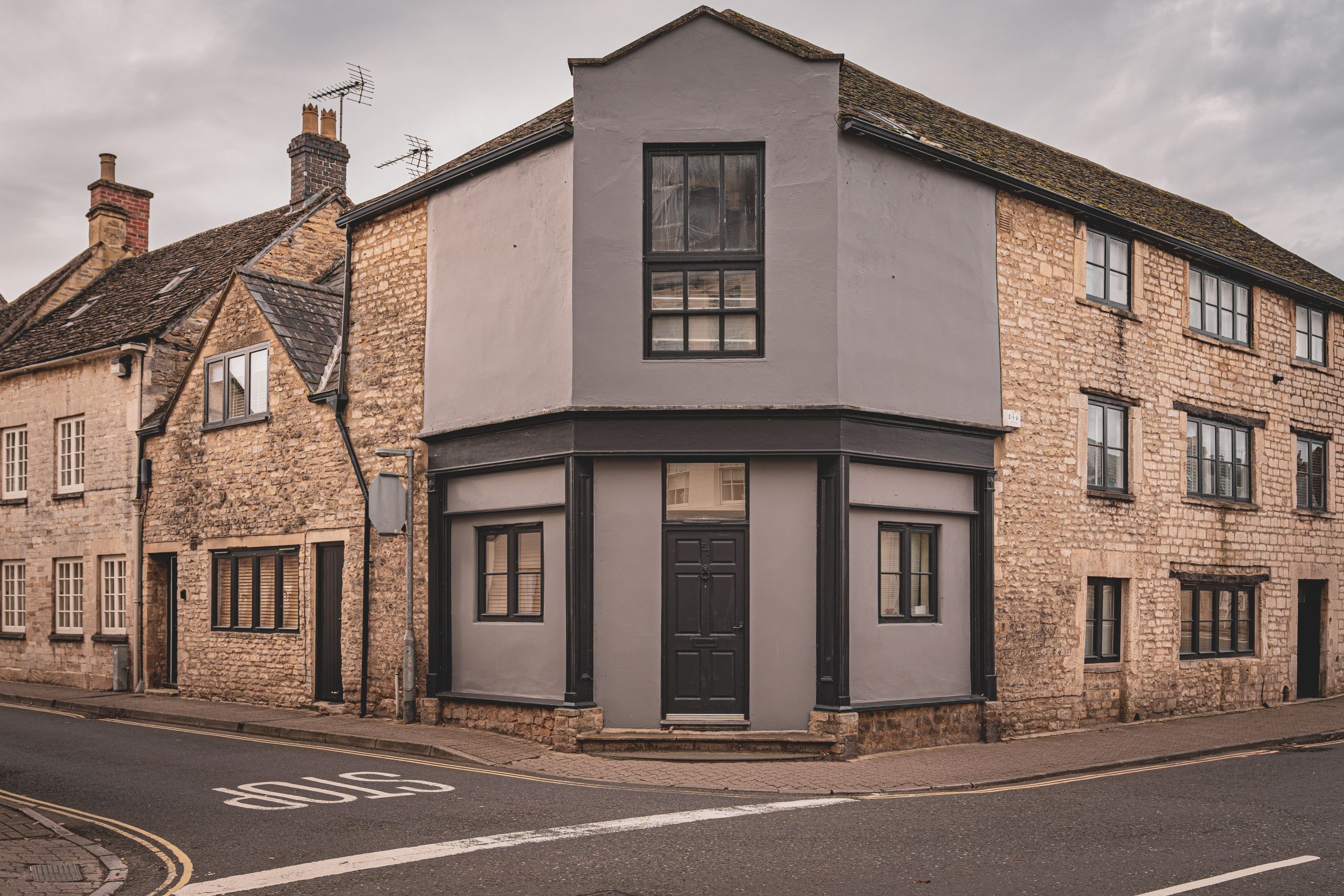 Rustic English stone buildings on a tranquil street, illustrating traditional period-home architecture.